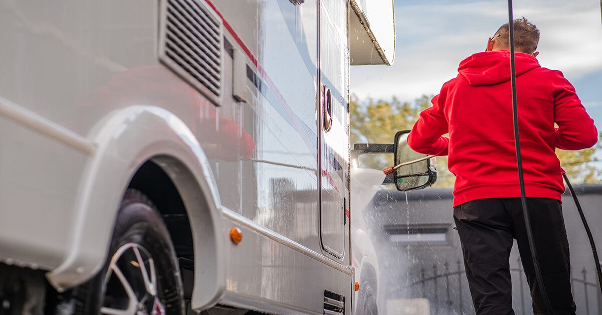 man in red hoodie cleans outside of rv