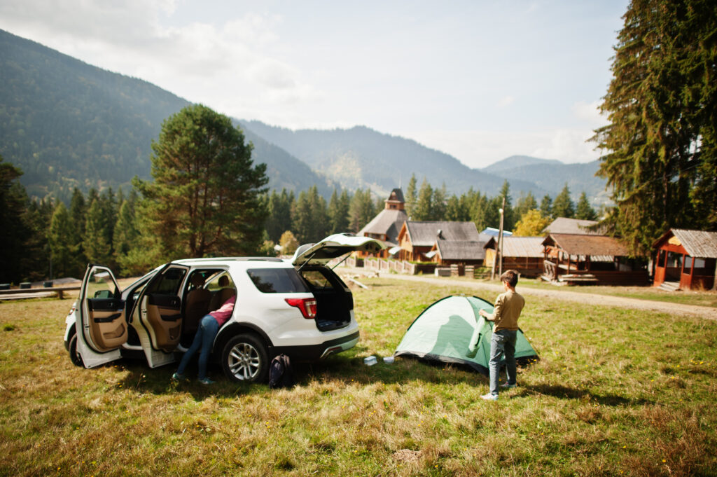 family-setting-up-campsite-tent-car