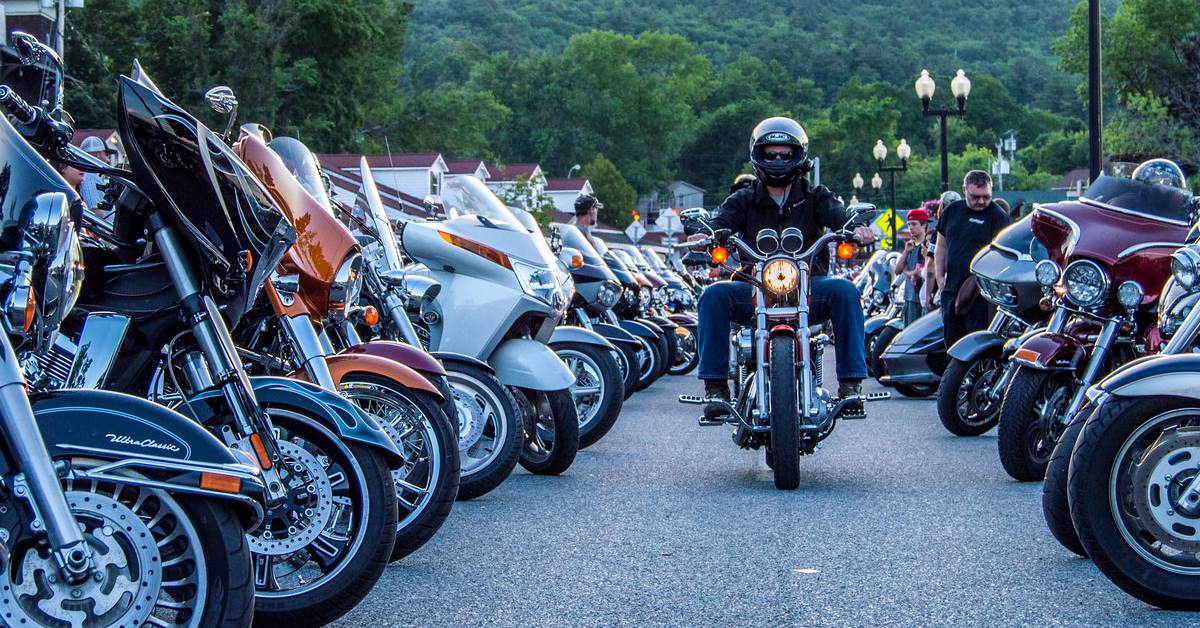 motorcyclist rides between rows of motorcycles