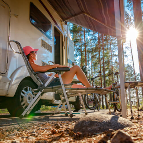 woman relaxes by camper