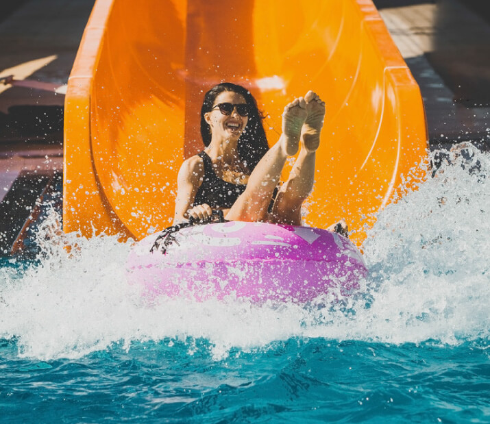 woman comes down waterslide on tube
