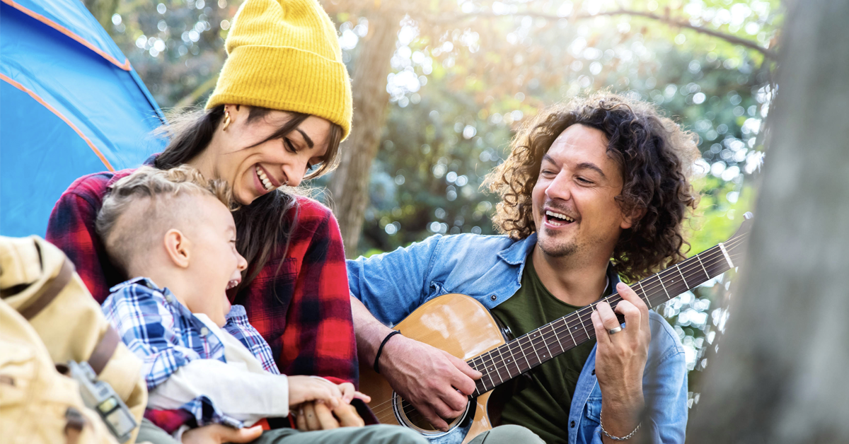 family-playing-guitar-outside-while-camping