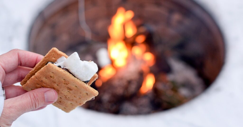 hand-holding-s'more-by-campfire