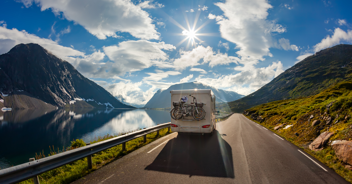 RV-driving-down-the-road-mountains-in-background