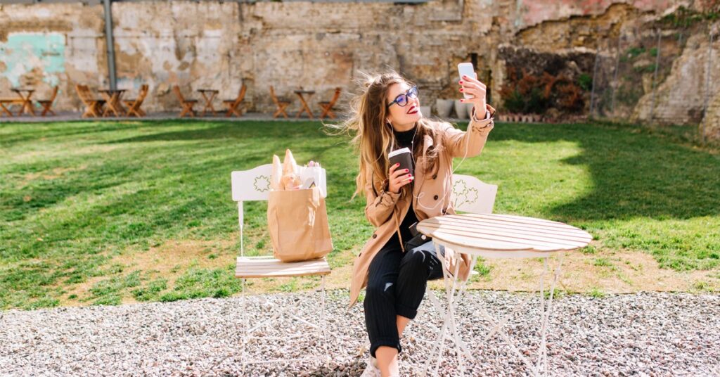 girl-posing-with-coffee-cup-taking-selfie