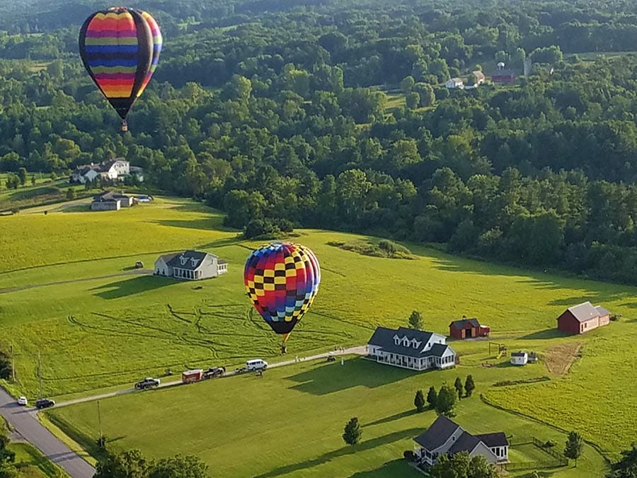 two hot air balloons over an open field
