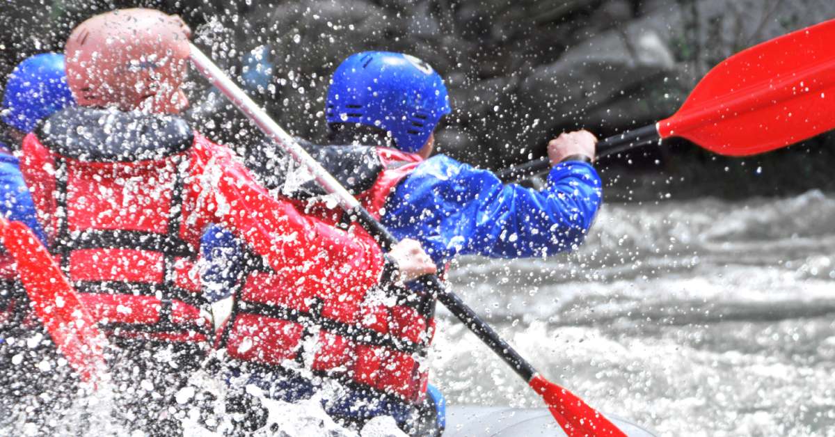 whitewater rafting with red lifejackets and paddles