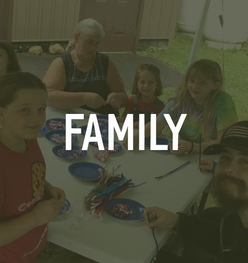 family sitting around a table doing a group craft activity with text overlay "family"