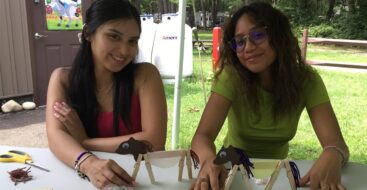 two teenage female campers making clothespin horses for craft activity