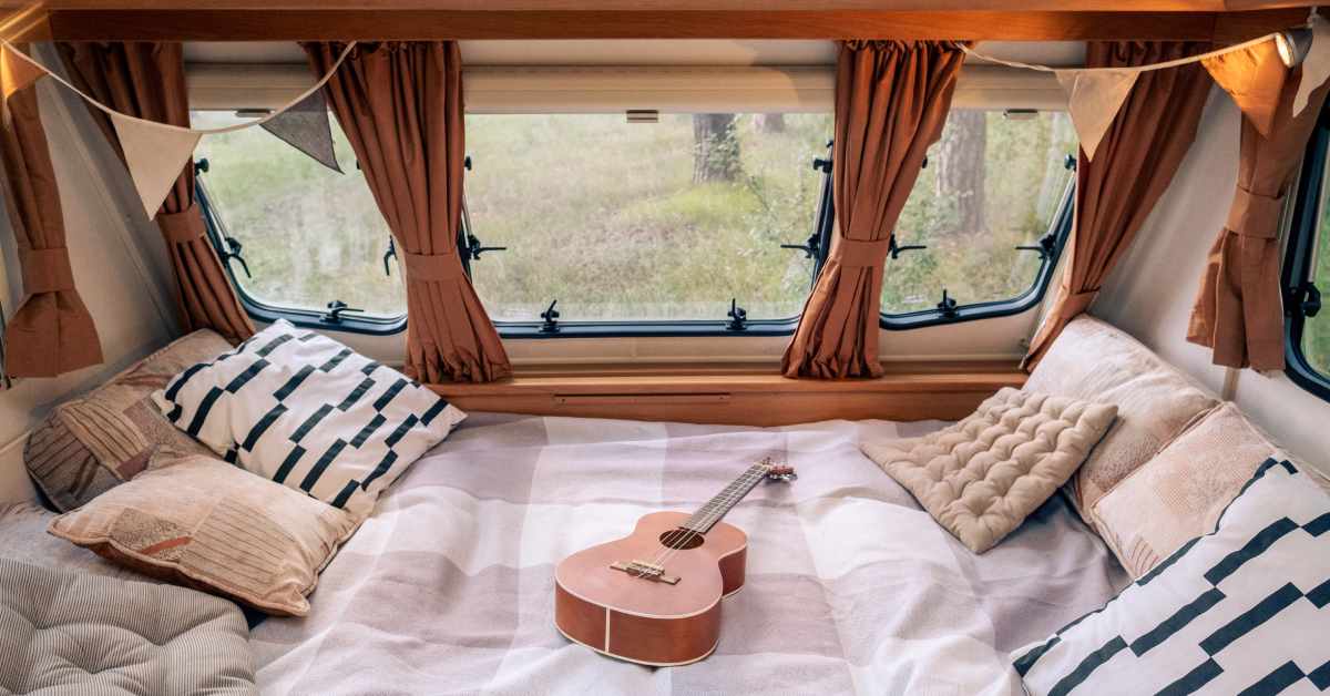 interior of rv camper with comfortable bedding and windows