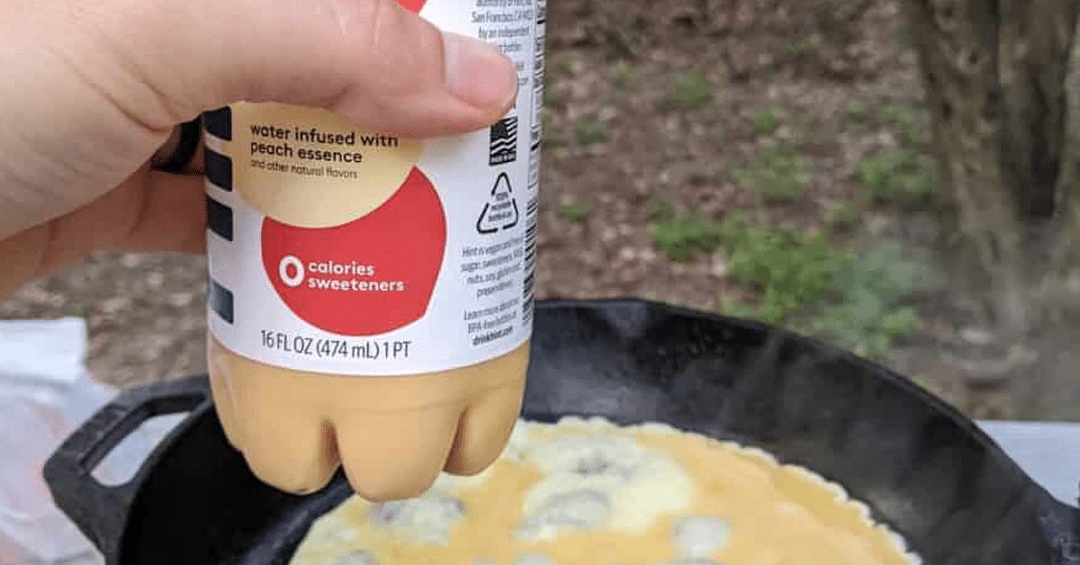 eggs in a water bottle held out over skillet with eggs